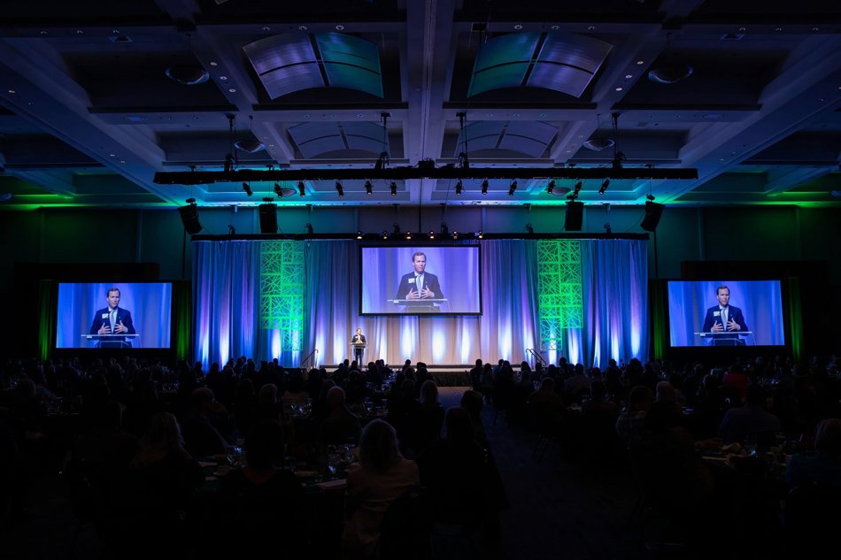 Executive keynote presentation during corporate conference with large audience