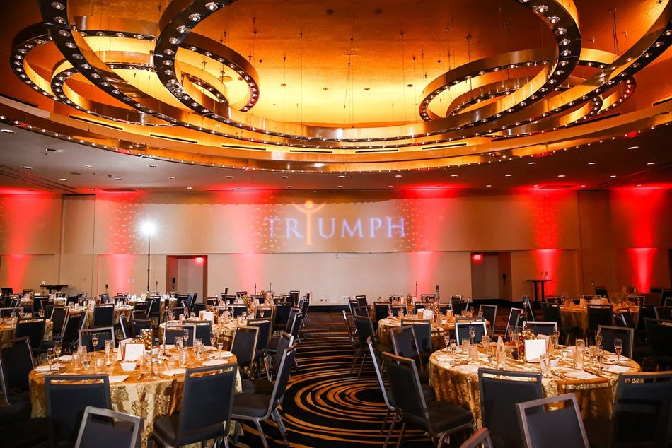Corporate gala dinner setup with gold lighting and elegant event décor