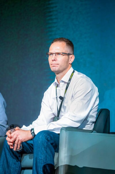 Three panelists seated on stage during GE Verona Conference in Arizona